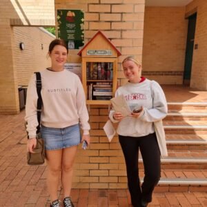 Two members of Book Club standing in front of the Street Library