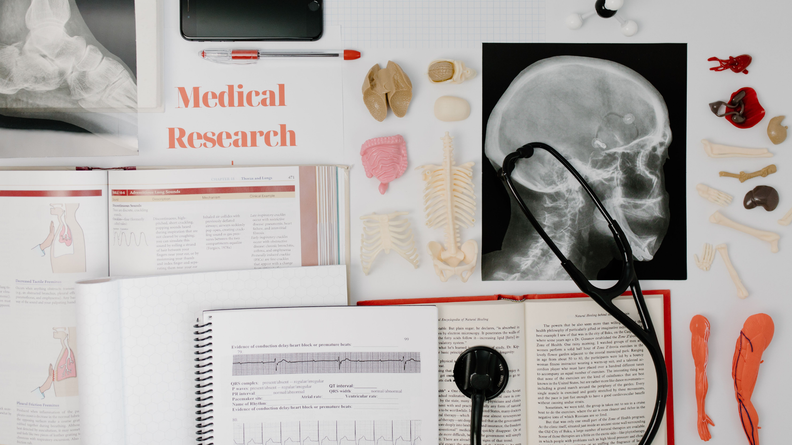 Overhead view of medical research equipment and study materials including books, x-rays, and stethoscope. Captured by Tara Winstead. Accessed at https://www.pexels.com/photo/black-and-silver-bluetooth-earbuds-7723389/